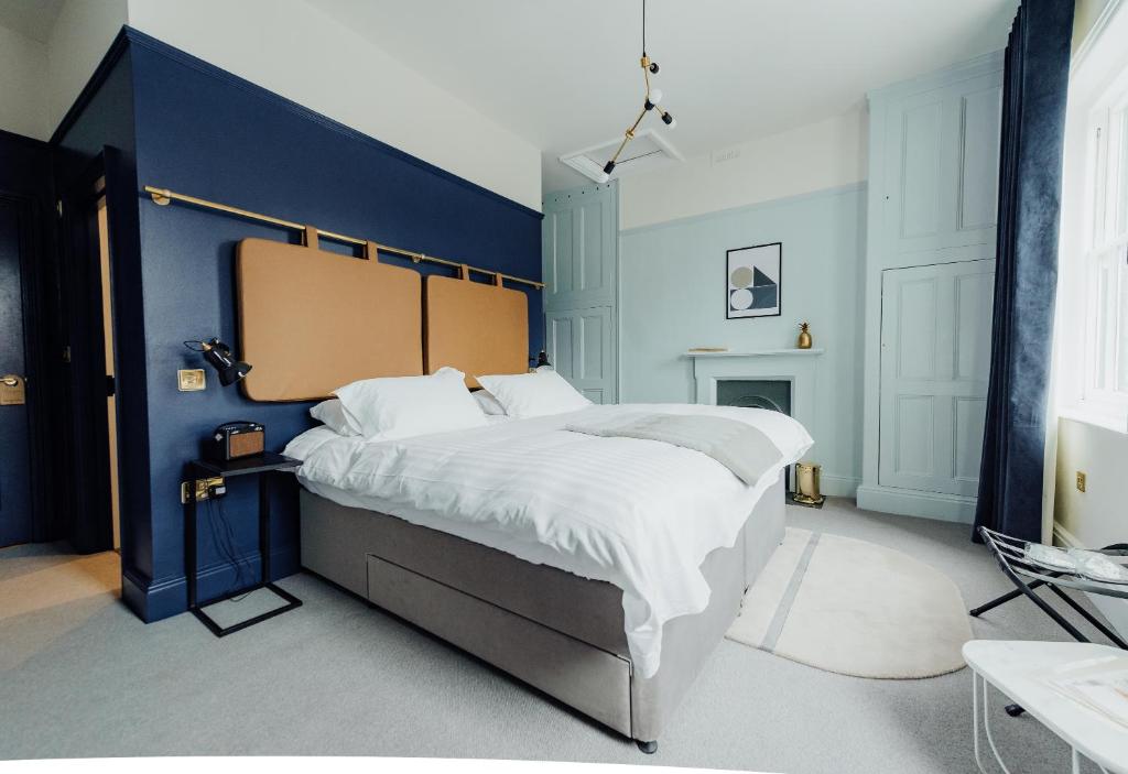 a bedroom with a large bed with a blue wall at The Masons Arms Hotel in Louth