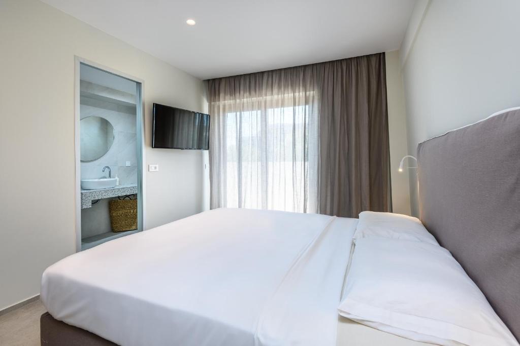 Łóżko lub łóżka w pokoju w obiekcie NOA BEACHFRONT SUITES