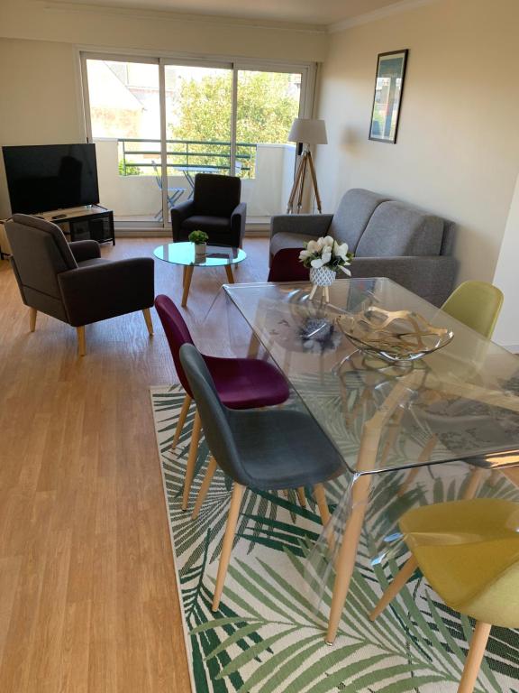 un salon avec une table en verre et des chaises dans l'établissement 65 m2 Centre vannes 2 ch wifi parking, à Vannes