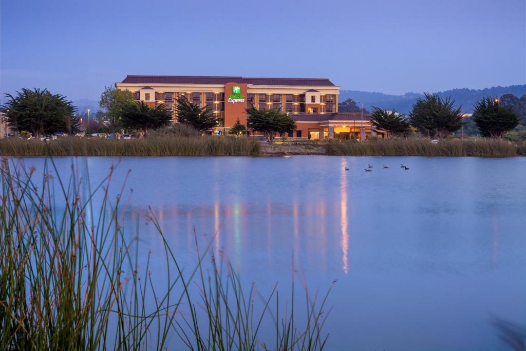 a large building with a lake in front of it at Holiday Inn Express at Monterey Bay, an IHG Hotel in Seaside