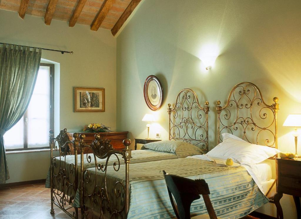 a bedroom with a bed and a table and a window at Agriturismo Santa Maria Bressanoro in Castelleone