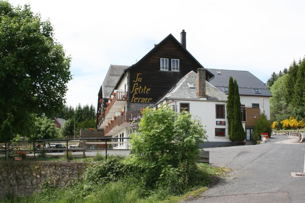 um edifício preto e branco com um cartaz em Auberge de la Petite Ferme, Super-Besse Est, The Originals Relais (Qualys-Hotel) em Besse-et-Saint-Anastaise