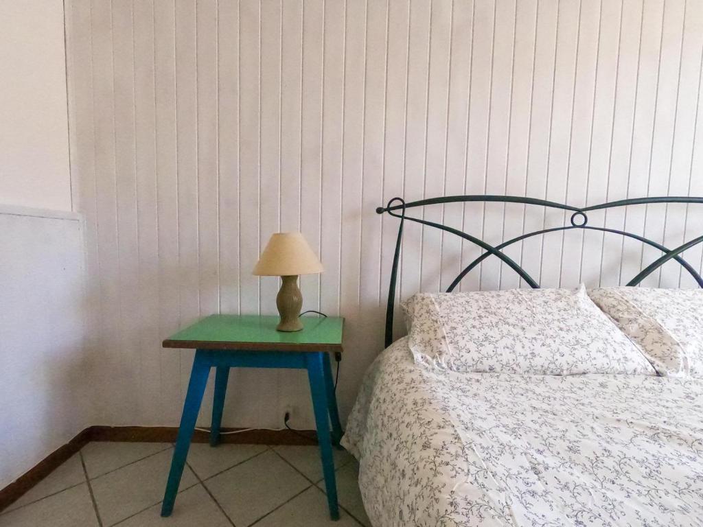 Una cama con una mesa verde con una lámpara. en Cà di N en Castel dʼAiano
