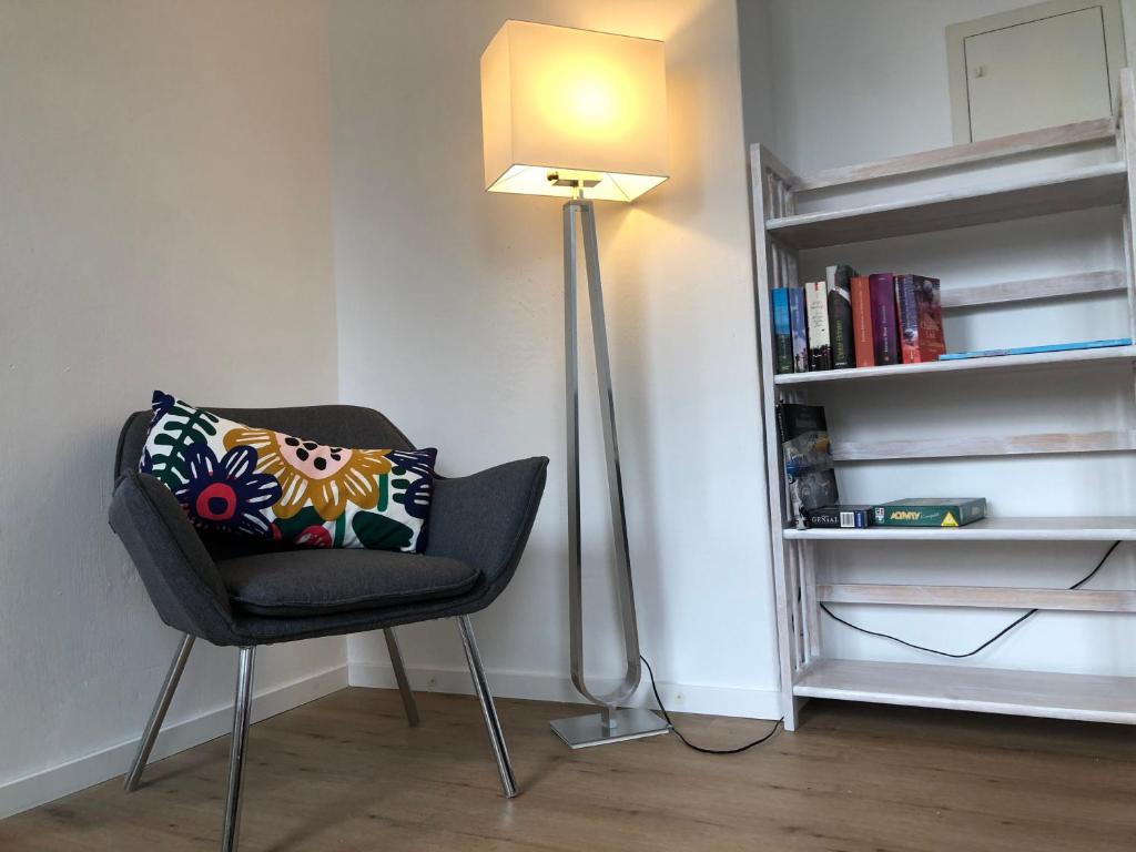 a chair with a pillow and a lamp in a room at Ferienwohnung Zur alten Schmiede in Kottenheim