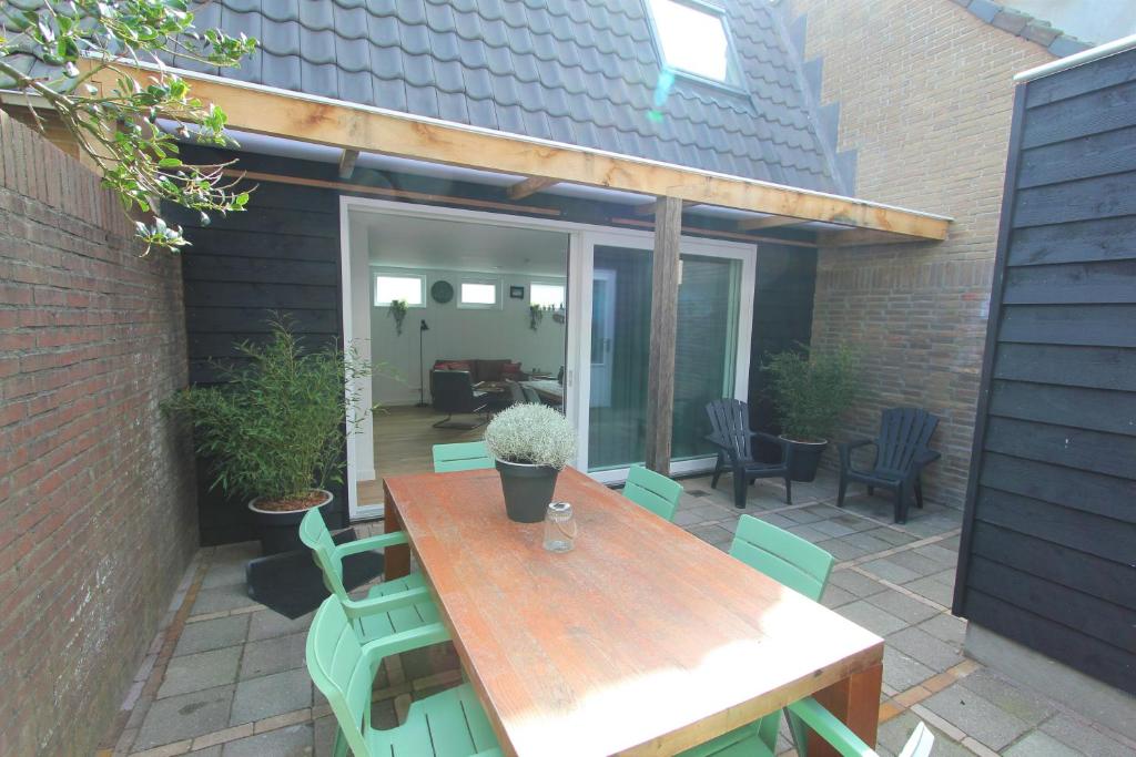 un patio con tavolo e sedie in legno di Beaufort a Egmond aan Zee