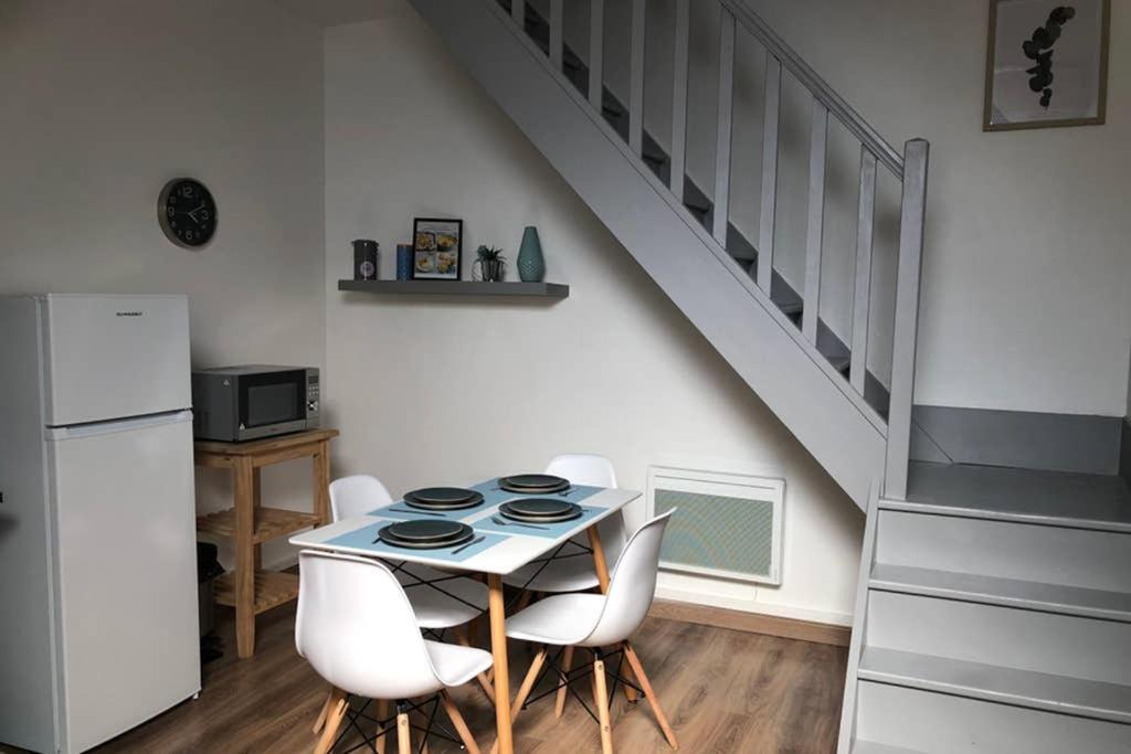 une cuisine avec une table et des chaises ainsi qu'un escalier dans l'établissement The blue flat 55m2 à côté de la Gare, à Châlons-en-Champagne