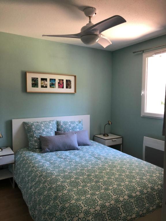 une chambre avec un lit et un ventilateur de plafond dans l'établissement Résidence Mas les Cigales 3 étoiles, à Castries