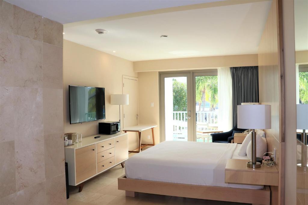 a hotel room with a bed and a television at The Mill Resort and Suites in Palm-Eagle Beach