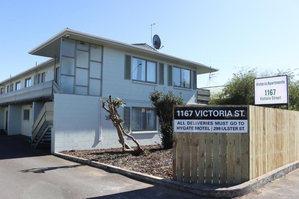 a house with a sign in front of it at Victoria Apartments in Hamilton