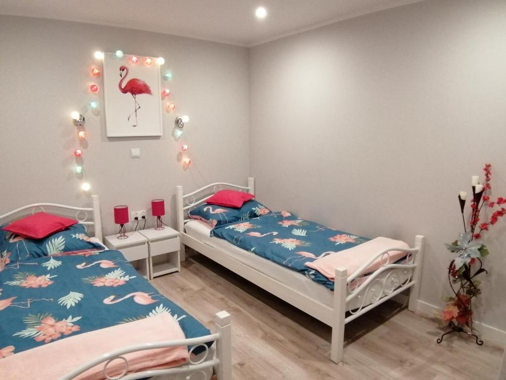 two beds in a room with christmas lights at Apartament Grosik in Duszniki Zdrój