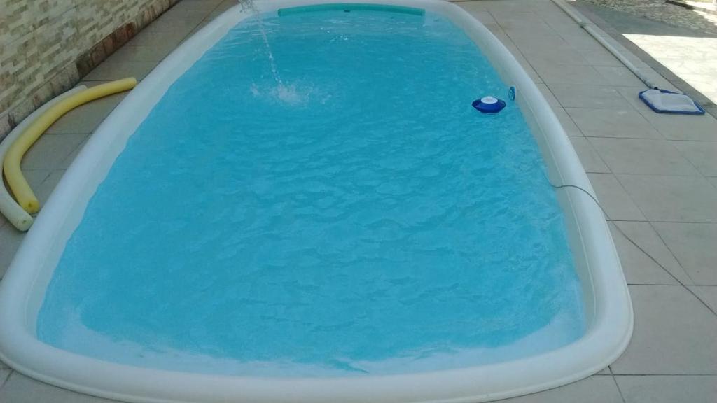 uma banheira cheia de água azul num piso de azulejo em Saquarema2 em Saquarema