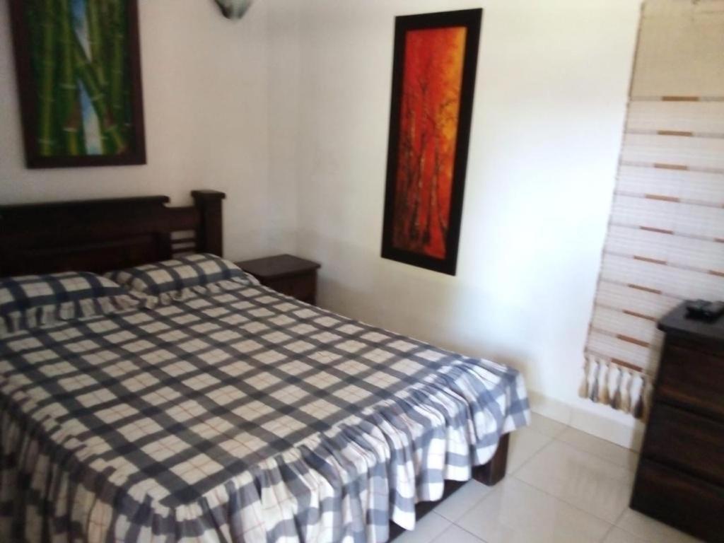 a bedroom with a bed and paintings on the wall at Finca Hotel La Ponderosa in Rionegro