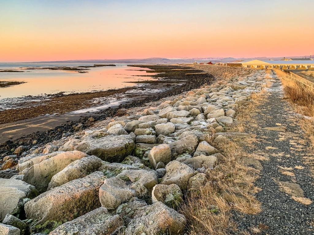 un grupo de rocas en la playa al atardecer en Bakki Apartments & Hostel, en Eyrarbakki