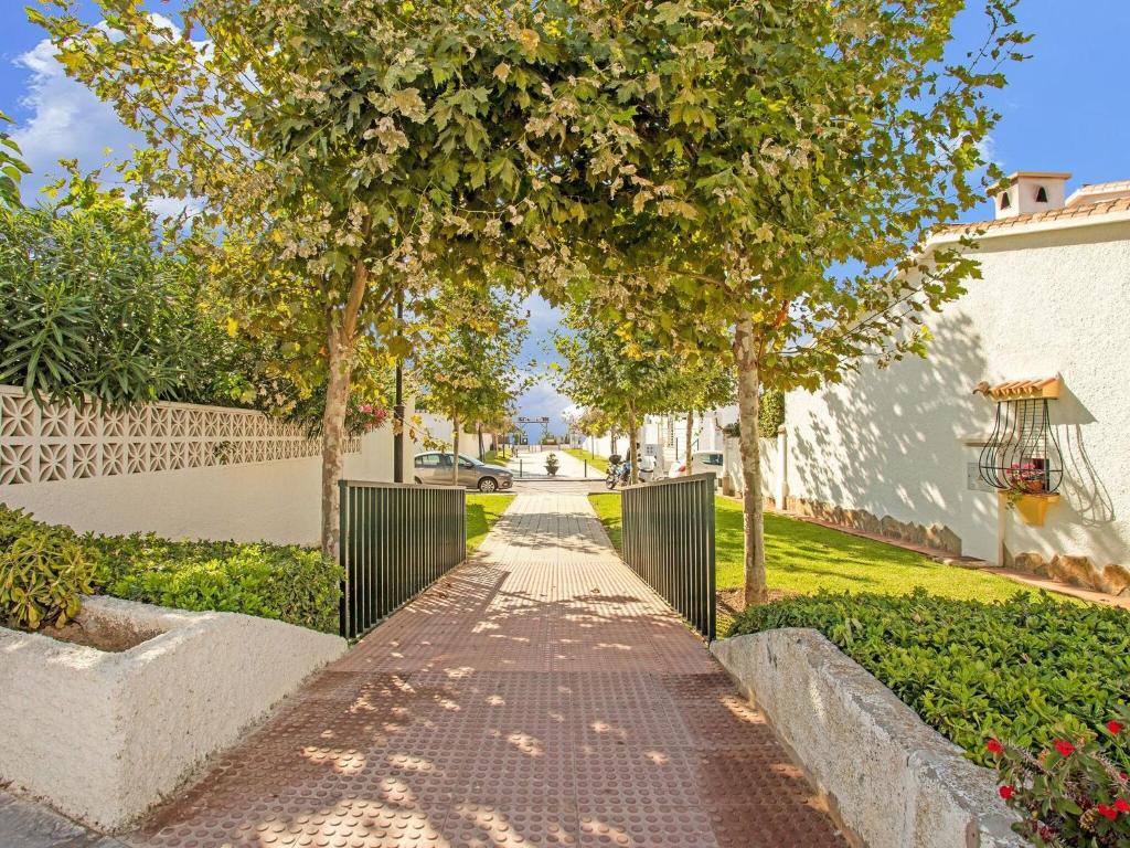 a walkway in a park with trees and bushes at Comfortable holiday home close to the beach in La Cala de Mijas in La Cala de Mijas
