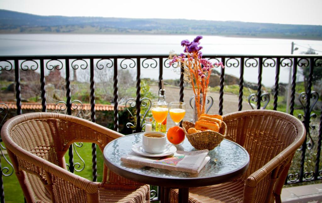 una mesa con una bandeja de comida y bebida en el balcón en Hotel Rural Salvatierra en Salvatierra de Tormes