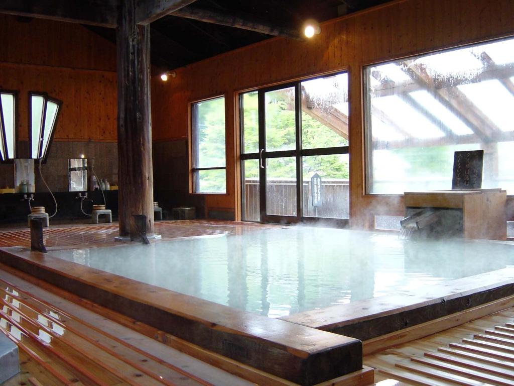 Habitación grande con pista de baile y ventanas. en Manza Onsen Nisshinkan, en Tsumagoi