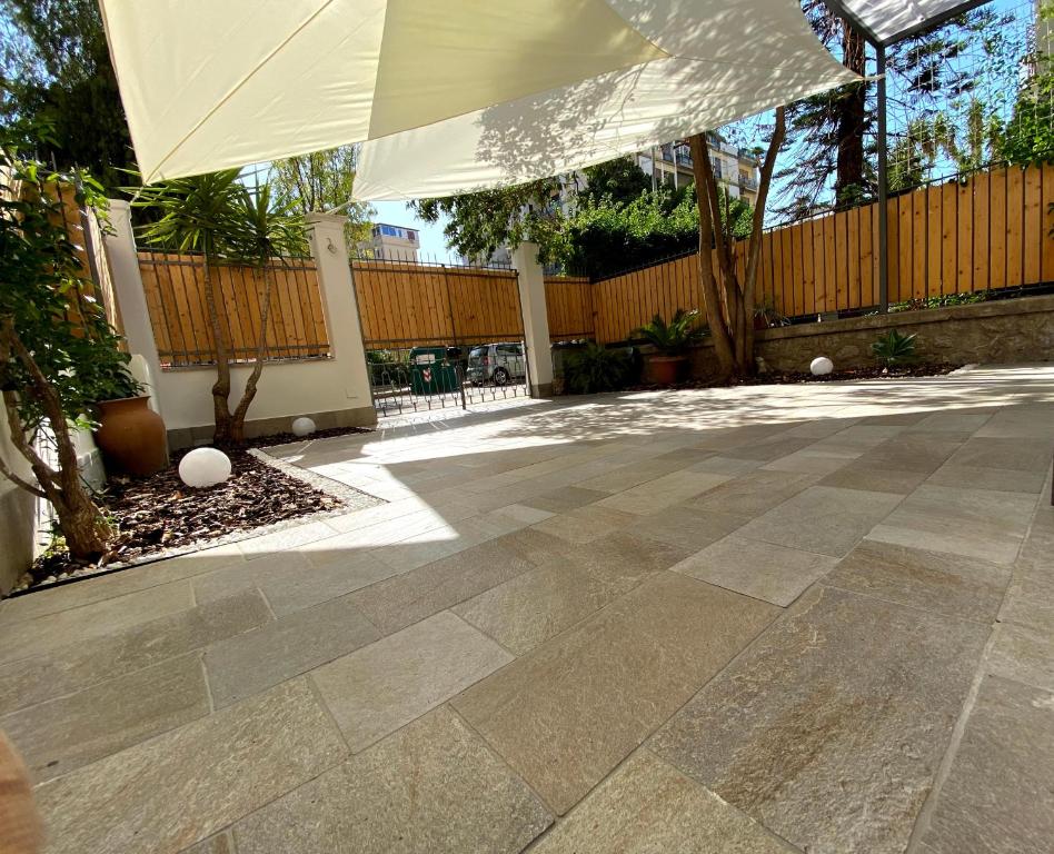 patio z białym parasolem i ogrodzeniem w obiekcie casa vacanze Sleep Art w mieście Palermo
