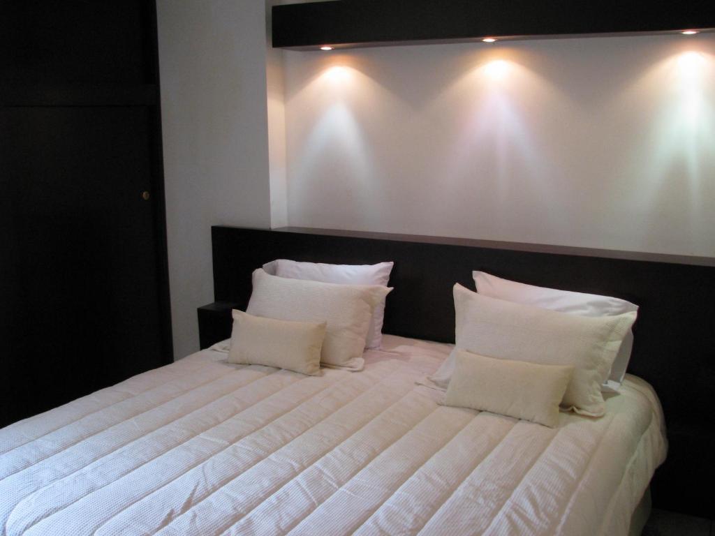 a bedroom with a large white bed with white pillows at Hotel Mar Azul Inn in Santa Marta