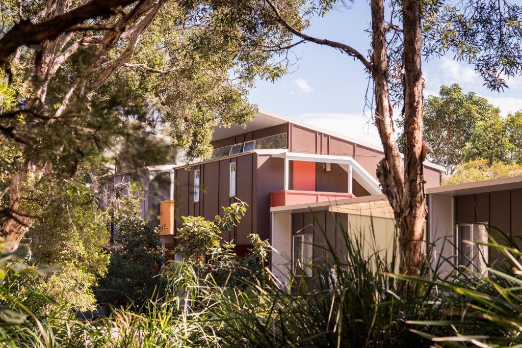 a house on the hill with trees in the foreground at Allure Stradbroke Resort in Point Lookout