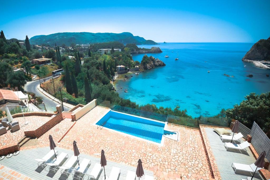 a villa with a swimming pool and a view of the ocean at Platakia Blu in Paleokastritsa