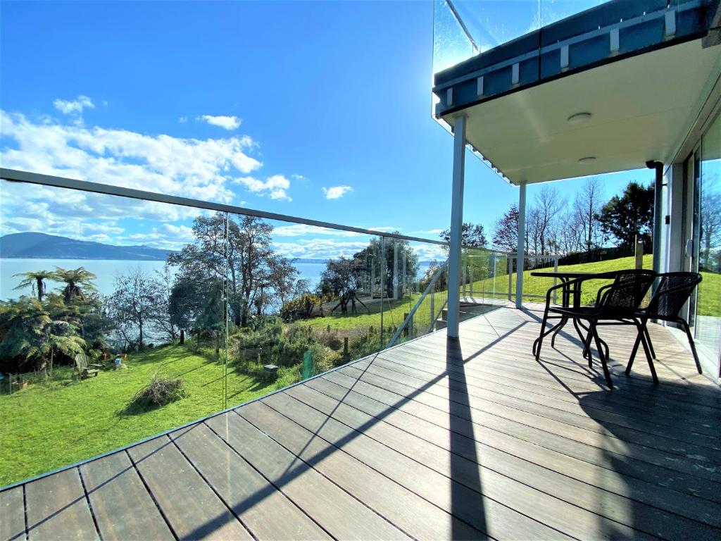 a balcony of a house with a view of the water at Addictive View - Lakeside Studio in Rotorua