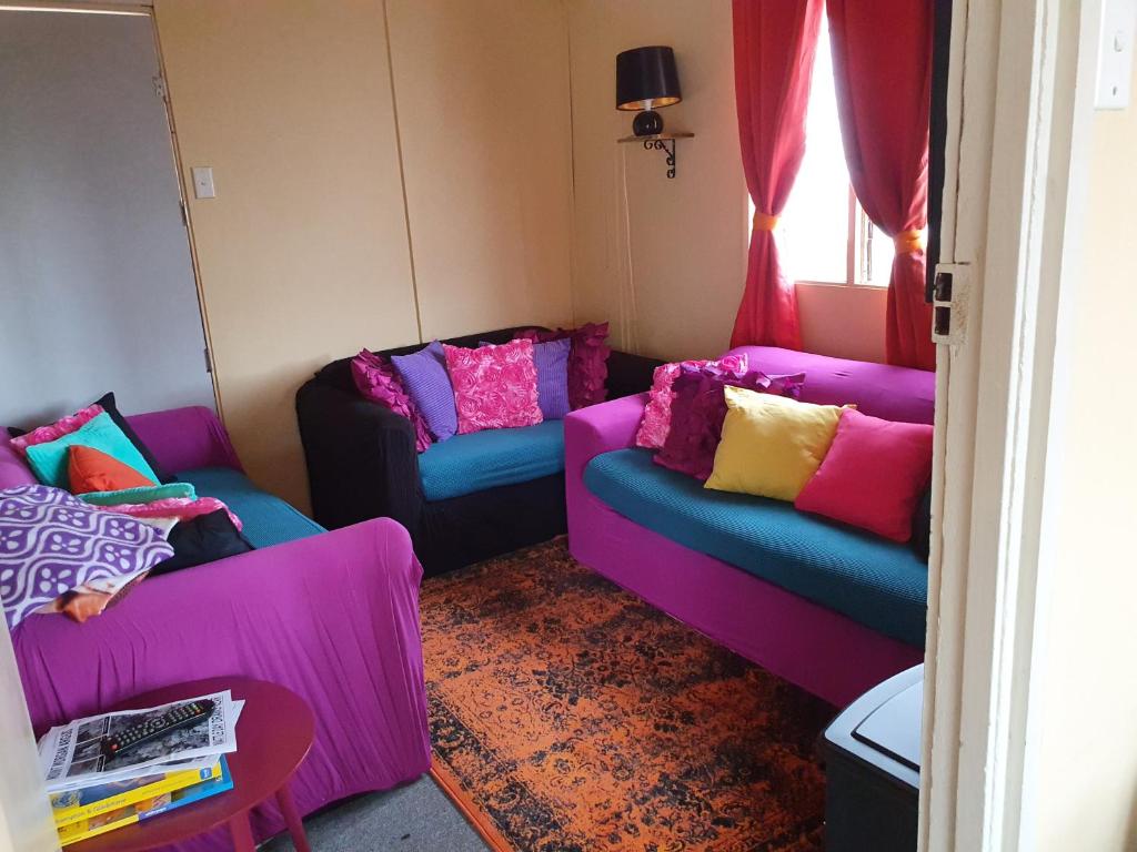 a living room with two couches with colorful pillows at Golden Mt Rest on James in Mount Morgan