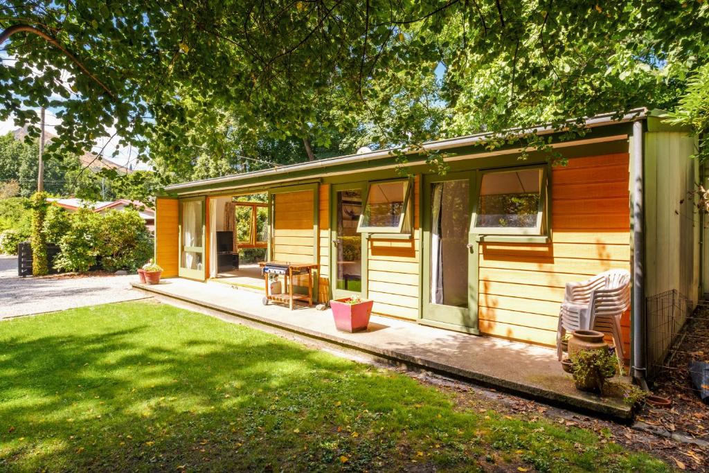 una pequeña casa con porche y patio en Merioneth Retreat - Arrowtown Holiday Home, en Arrowtown