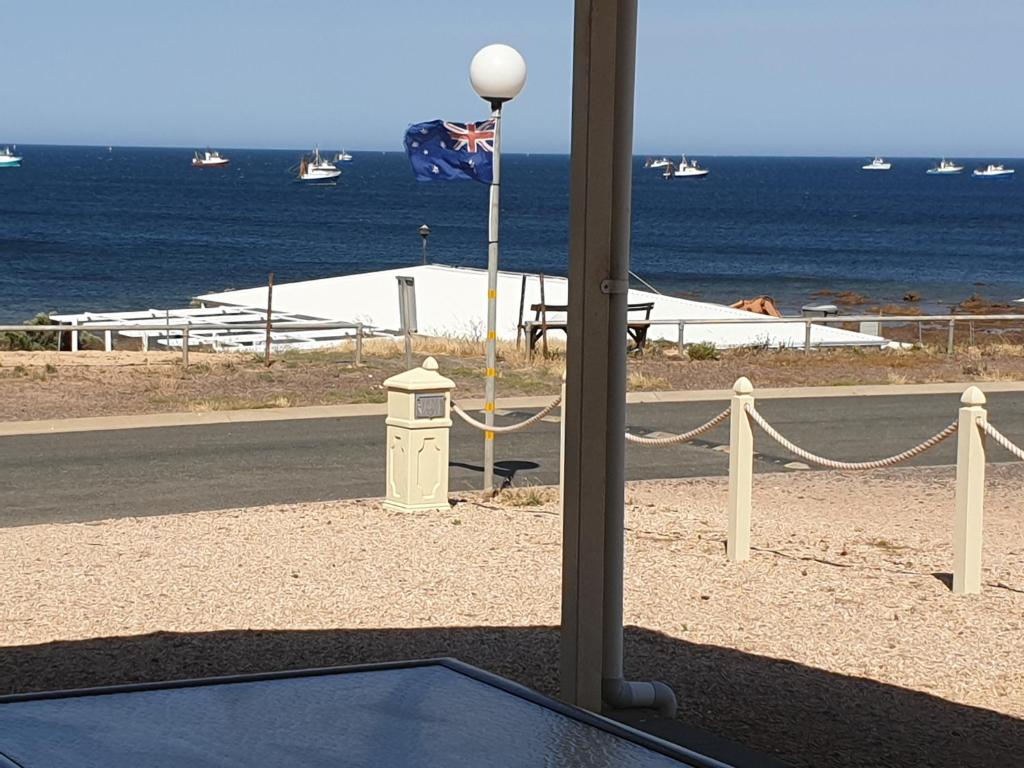 uma vista para o oceano com uma bandeira e uma mesa em Wallaroo Sunset home em Wallaroo