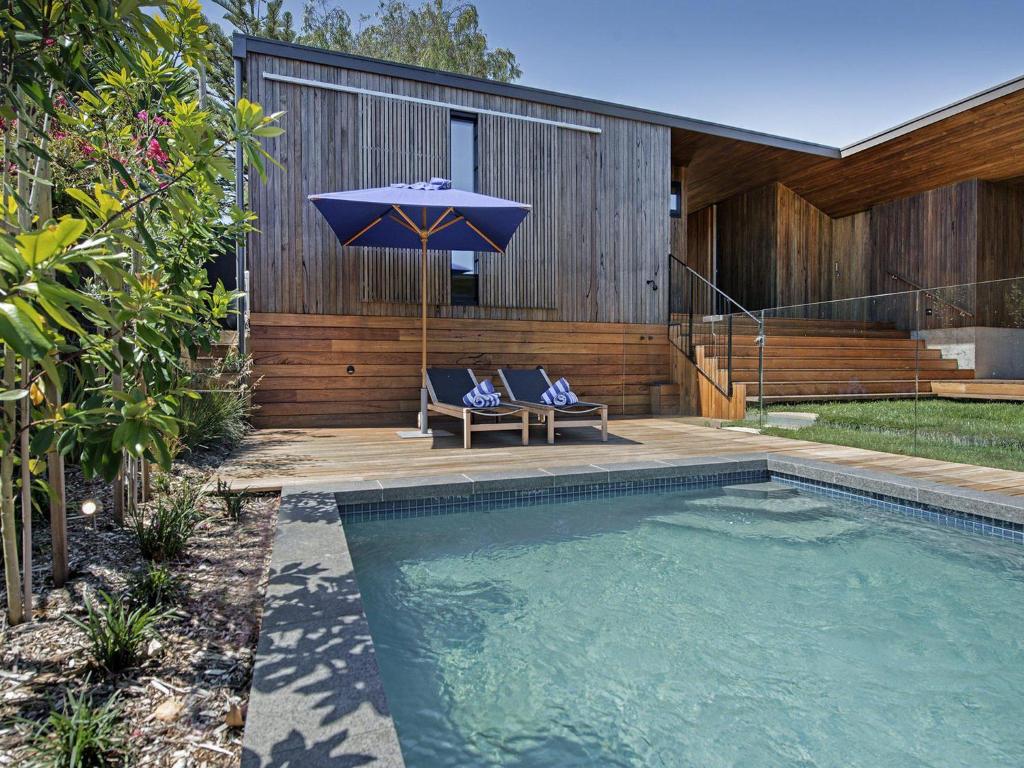 a swimming pool with an umbrella next to a house at Amagansett in Sorrento