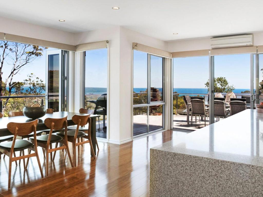 a dining room with views of the ocean at Bella Vista in McCrae