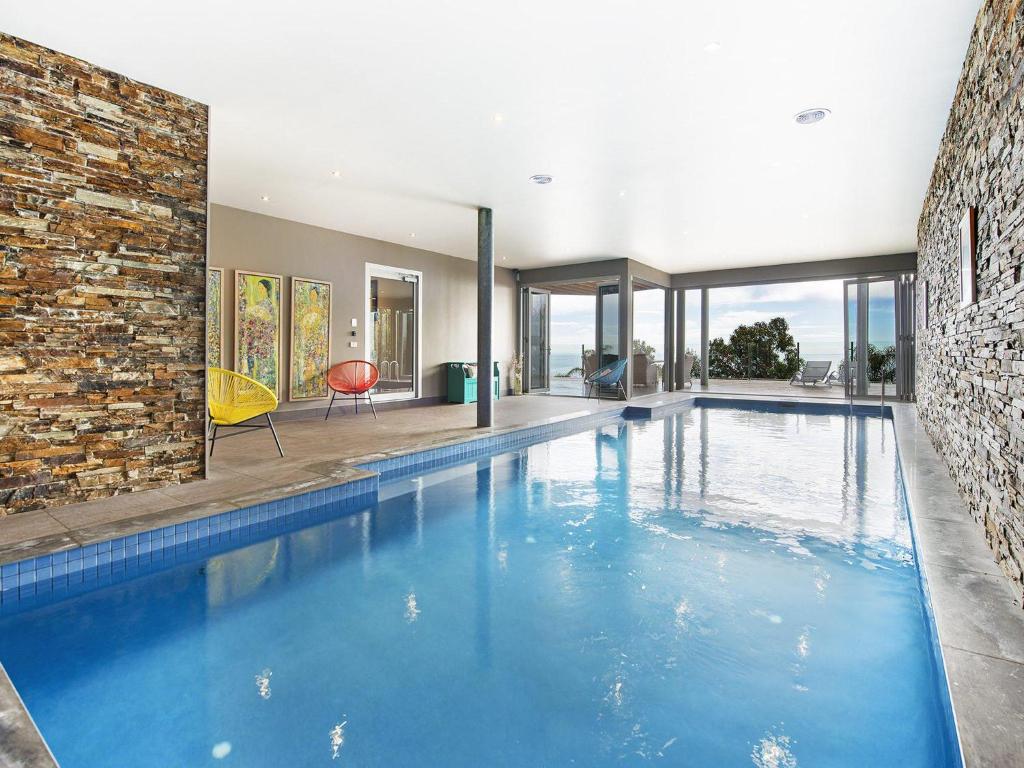 a swimming pool in a house with a brick wall at Bellevue sur Mer in Dromana