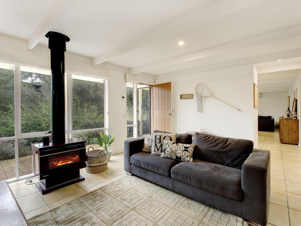 a living room with a couch and a wood stove at Quarterdeck in Portsea