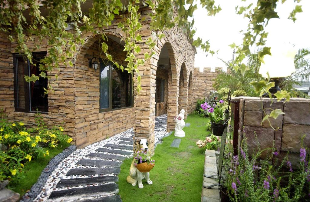 two dogs standing in front of a brick building at Xin Yuan My Dream Castle in Dongshan