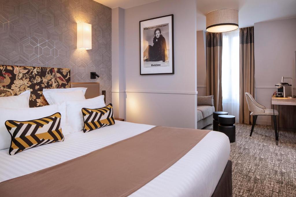 a hotel room with a large bed with two pillows at Daunou Opéra in Paris