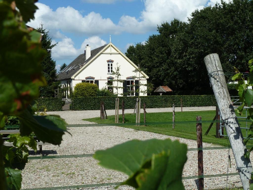 una casa blanca con una valla delante en B&B Hofstede De Groote Laar en Spankeren