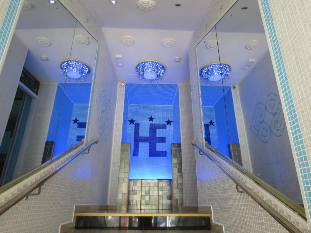 un escalier dans un bâtiment avec une croix sur le mur dans l'établissement Hotel Esperia, à Sanremo