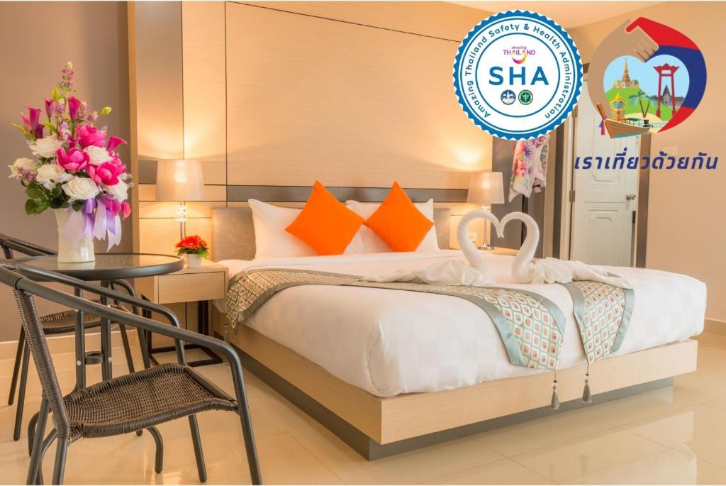 a bed room with a white bedspread and a clock on the wall at The Smart Hotel Hat Yai in Hat Yai