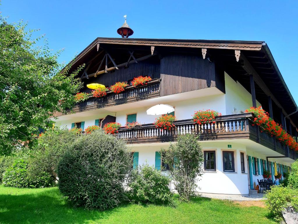 a building with a balcony with flowers on it at Gschwendtnerhof App10 KrausW in Aschau im Chiemgau