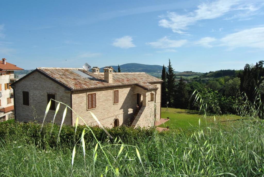 an old house in a field of tall grass at La Finestra sul Conero in Castelfidardo