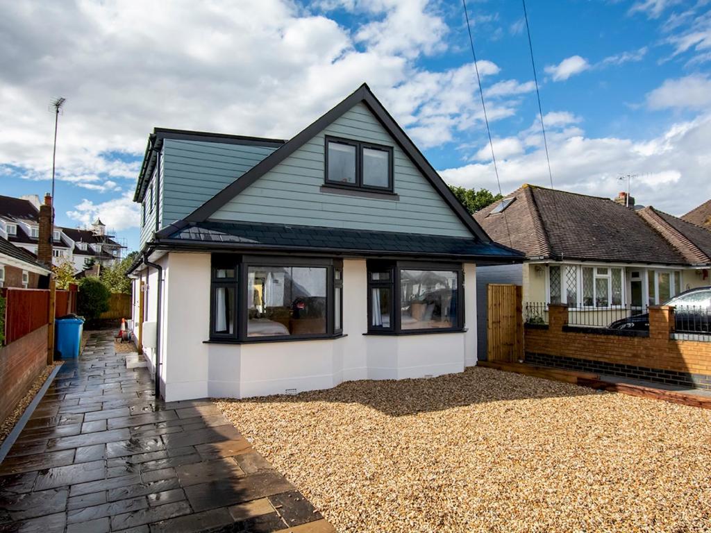 una pequeña casa blanca con techo azul en 'Sea Breeze' Dorset dream holiday home, en Poole