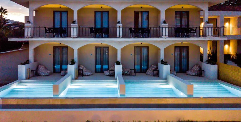 a large building with a swimming pool in front of it at Agave Boutique Hotel in Laganas