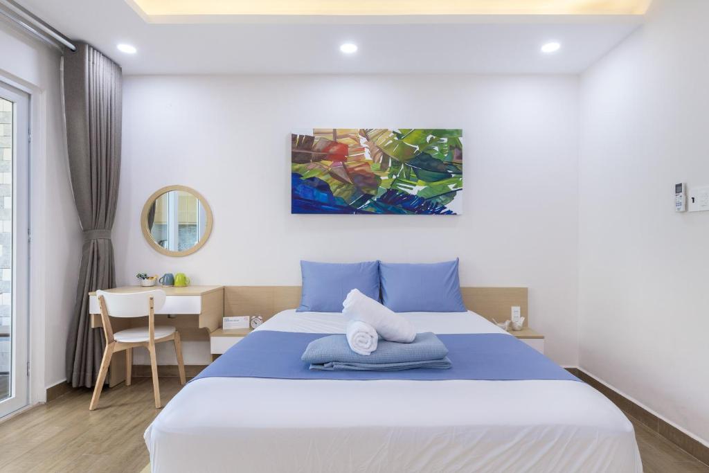 a bedroom with a large bed and a desk at Cozrum Homes - Yoga Corner in Ho Chi Minh City