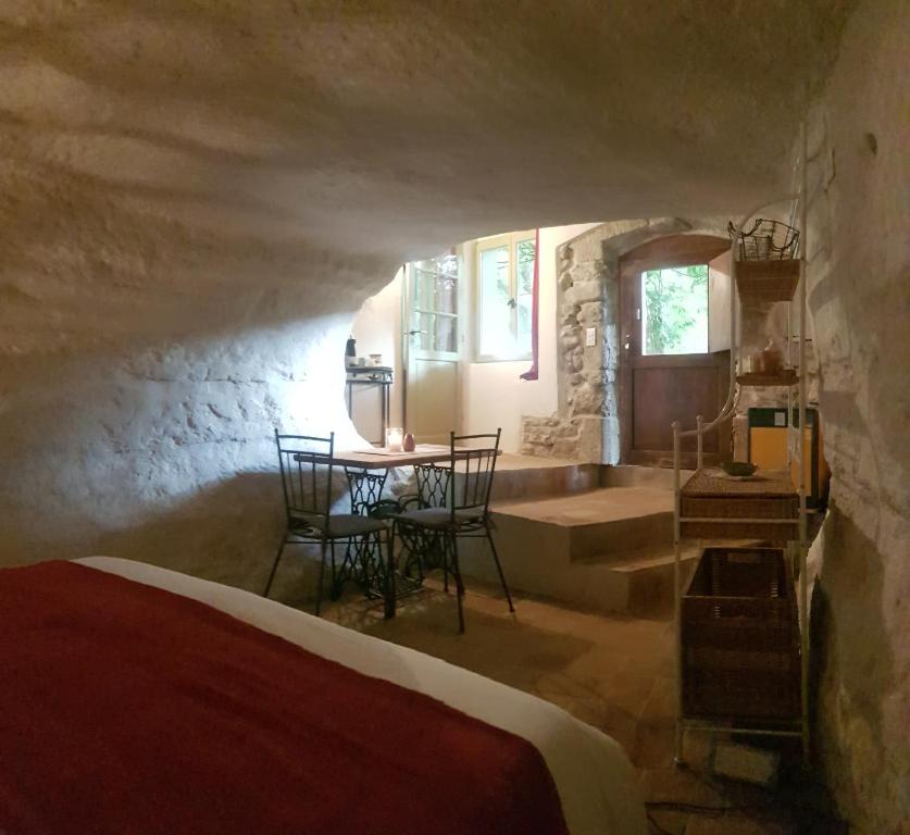 een slaapkamer met een bed en een tafel in een kamer bij Moulin de Bonfilhon in Cornillon-Confoux