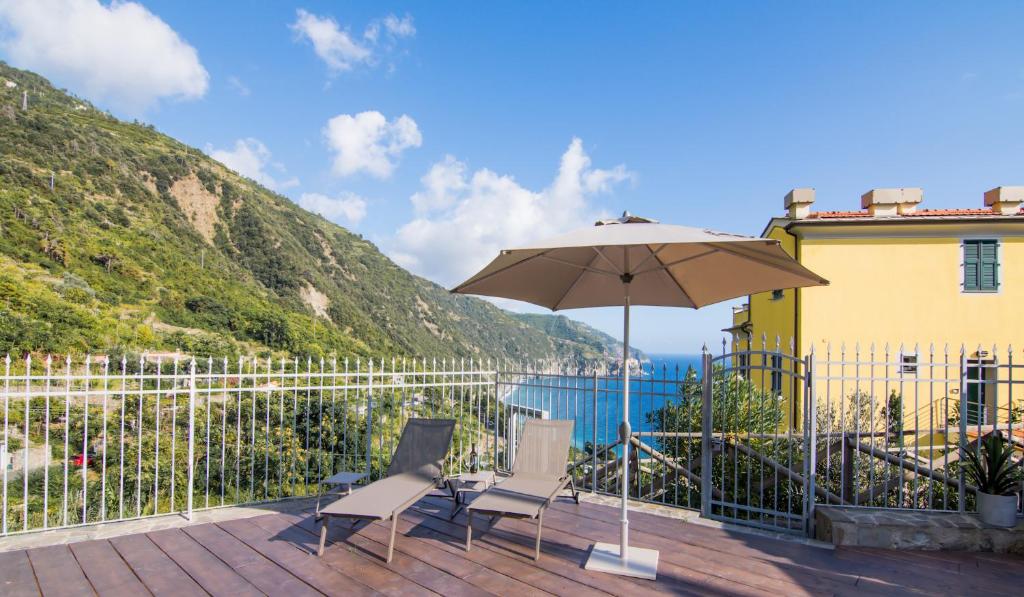 a patio with two chairs and an umbrella at Locanda Il Carugio in Corniglia