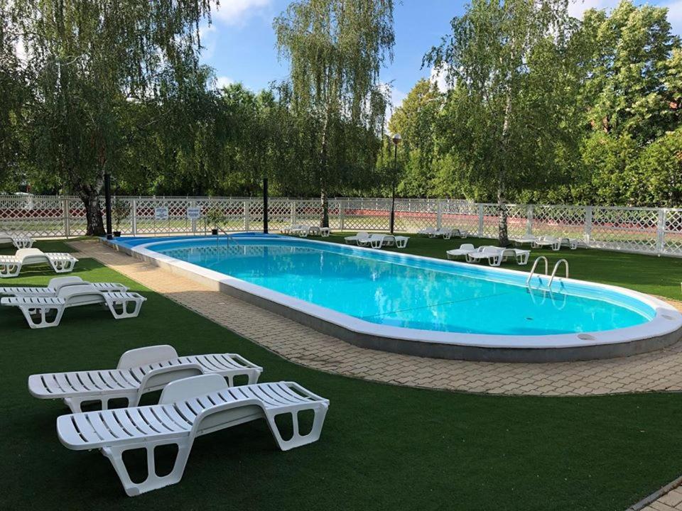 a swimming pool with chaise lounge chairs and a swimming pool at Mátyás Király Gyógy- és Wellness Hotel in Hajdúszoboszló