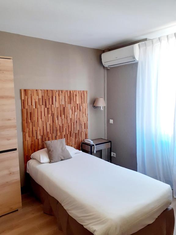 a bedroom with a large white bed and a window at Hôtel La Villa Tosca in Cannes