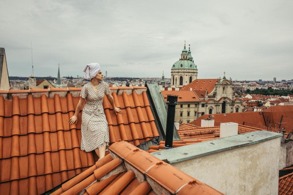 a woman standing on top of a tall building at Residence Thunovska in Prague