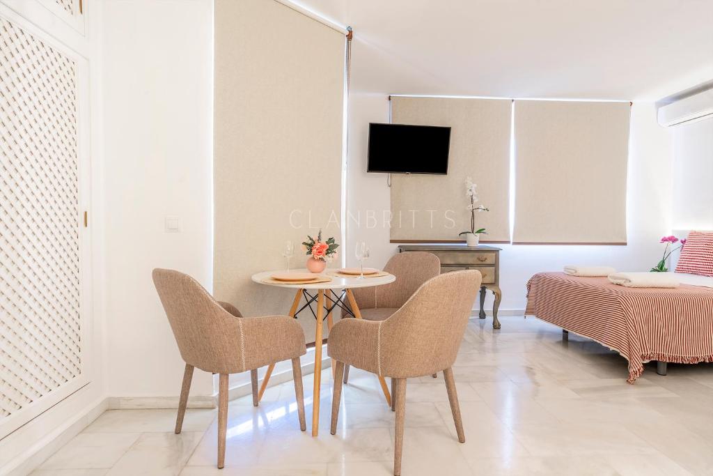 jadalnia ze stołem i krzesłami oraz telewizorem w obiekcie Apartamento Marina Loft w mieście Benalmádena
