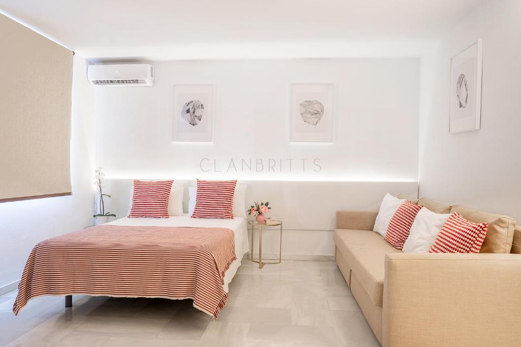sypialnia z łóżkiem i kanapą w obiekcie Apartamento Marina Loft w mieście Benalmádena