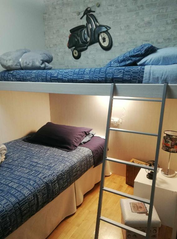 sypialnia z 2 łóżkami piętrowymi i skuterem na górze w obiekcie La casa del gatico w mieście Lumbier